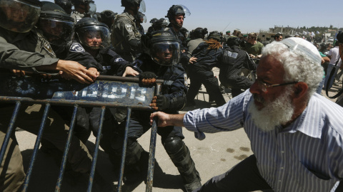 Un colono judío se enfrenta a miembros de las Fuerzas de seguridad israelíes, durante la demolición de un inmueble en el asentamiento judío de Bet El, cerca de la ciudad cisjordana de Ramala, hoy, 29 de julio de 2015. El movimiento colono j