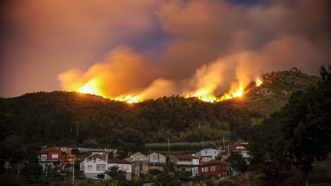 Vista del pueblo de Untes rodeado por las llamas del incendio forestal registrado en las afueras de la ciudad de Ourense, que ha ido adquiriendo grandes dimensiones y ha obligado a decretar el nivel dos de riesgo, ya que ha rodeado vivienda