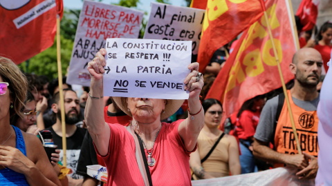 Una mujer sujeta su pancarta durante la concentración contra Milei, a 27 de diciembre de 2023, en Buenos Aires.