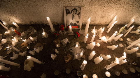 Detalle de una fotografía de uno de los detenidos desaparecidos durante la dictadura chilena (1973-1990) rodeado de velas en el Estadio Nacional de Chile, durante uno de los actos de conmemoración por el 46º aniversario del golpe de Estado 