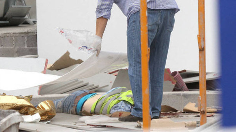 Una persona cubre con un plástico el cadáver de un trabajador fallecido (Imagen de archivo). (EFE)