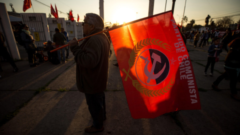 Un hombre con la bandera del Partido Comunista de Chile en las afueras del Estadio Nacional de Chile, uno de los centros de detención de la dictadura de Augusto Pinochet (1973-1990), durante uno de los actos de conmemoración por el 46º aniv