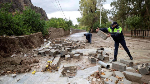 Policías locales de Blanca, Murcia, retiran los bloques de un muro derribado por las fuertes lluvias. - EFE