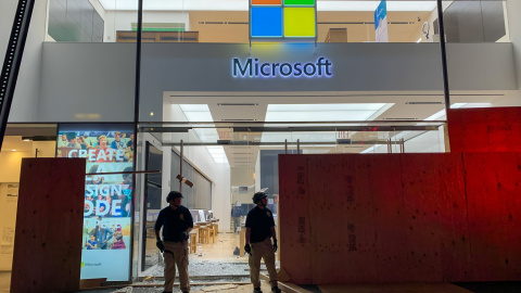 Los miembros de seguridad montan guardia frente a la Microsoft Store destruida en la quinta avenida