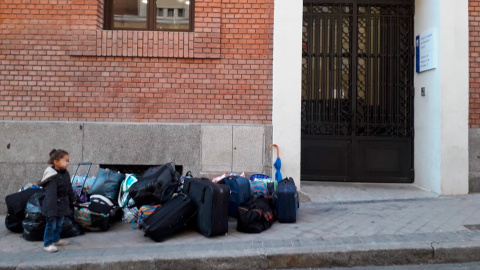 Una de las hijas de la familia desalojada junto a todas sus pertenencias en la puerta del albergue municipal de Alonso Martínez.- @Pavps_Madrid