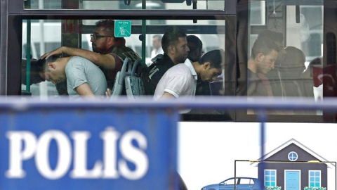 Policías turcos escoltan en un bus a soldados detenidos tras el golpe. - EFE