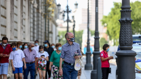 Varias personas pasean con mascarilla durante el último día de la obligatoriedad de mascarillas en exteriores, este viernes en Madrid. - EUROPA PRESS