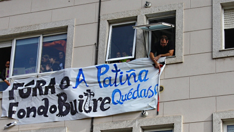 Imagen de archivo de los vecinos de A Patiña colgando una pancarta contra el fondo buitre que poseía anteriormente el edificio. - Juan Oliver