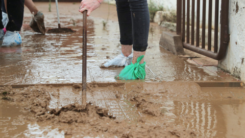 Una mujer limpia la entrada de una casa después de las inundaciones causadas por las lluvias torrenciales en San Javier, Murcia. REUTERS / Sergio Perez