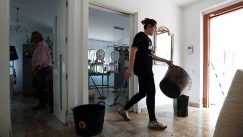 Una mujer limpia una casa después de las inundaciones causadas por lluvias torrenciales en San Javier.-REUTERS / SERGIO PÉREZ