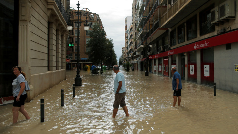 La gente camina por una calle inundada por las lluvias torrenciales en Orihuela, Alicante.- REUTERS/ JON NAZCA