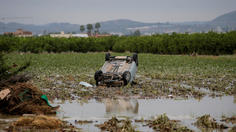 Un automóvil volcado en mitad de un campo tras ser arrastrado por las lluvias torrenciales de la gota fría en Orihuela.- REUTERS /  JON NAZCA