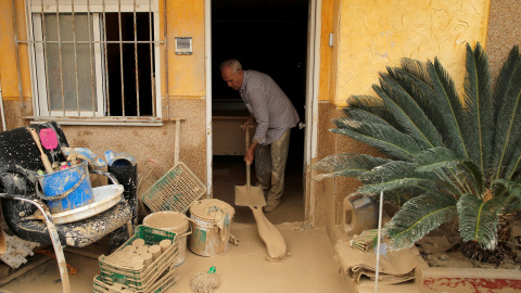 Un hombre elimina el lodo acumulado por las lluvias torrenciales en su casa de Orihuela, Alicante.- JON NAZCA / REUTERS