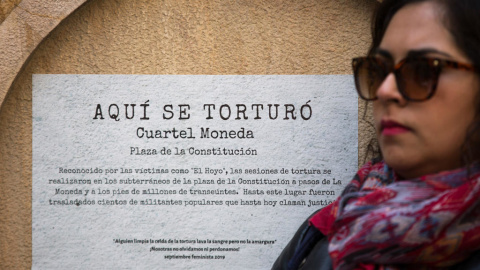 Una mujer se manifiesta este 10 de septiembre frente a un cartel que conmemora uno de los centros de tortura de la dictadura de Augusto Pinochet en Santiago de Chile Alberto Valdés / EFE