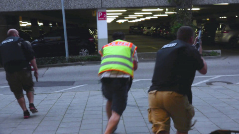 Una captura de pantalla de un vídeo muestra a policías con ropa de calle en el aparcamiento del centro comercial Olympia. REUTERS/Marc Mueller