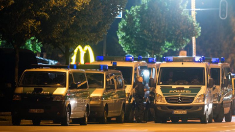 Furgones policiales junto a la hamburguesería donde se produjo el tiroteo. - EFE