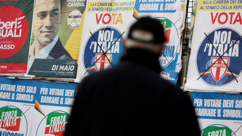 Un hombre junto a varios carteles electorales en la localidad de  Pomigliano D'Arco, cerca de Nápoles. REUTERS/Alessandro Bianchi