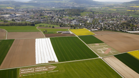 Vista aérea de un cartel gigante que muestra la distancia a la planta suiza nuclear de Beznau, la más antigua que operan en el mundo, colocado por el grupo de protesta ecologista Greenpeace en un campo cercano al aeropuerto de Zurich, cerca