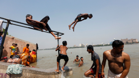 Unos muchachos saltan en el río Ganges para refrescarse en un día caluroso de verano en las afueras de Calcuta, India. REUTERS/Rupak De Chowdhuri