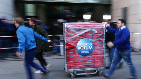 Los trabajadores del SPD llevan una carretilla con los votos de los militantes en la consulta sobre la repetición de la gran coalición con la CDU de Angela Merkel. REUTERS/Hannibal Hanschke