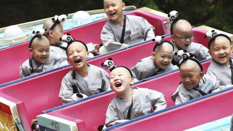 Jóvenes monjes budistas disfrutan de una atracción en un parque de atracciones en Seúl, Corea del Sur. EFE/Yonhap