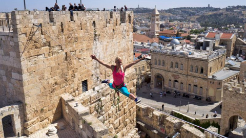 La estadounidense Heather Larsen mantiene el equilibrio sobre un cable atado entre dos torres en el complejo de la ciudadela de la Torre de David en el casco viejo de Jerusalén, Israel. EFE/Jim Hollander