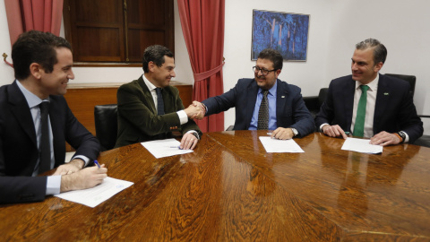 Los líderes andaluces del PP, Juan Manuel Moreno Bonilla, y de Vox, Francisco Serrano, estrechan las manos en presencia de los secretarios generales del PP, Teodoro García Egea, y de Vox, Francisco Javier Ortega Smith, durante la reunión en