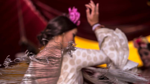 Una joven vestida de flamenca baila durante la Feria de Córdoba. EFE/Rafa Alcaide