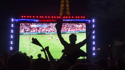 Hinchas ingleses ven en una pantalla gigante el partido de fútbol de la Eurocopa 2016 entre Inglaterra y Rusia frente de la Torre Eiffel en París. GEOFFROY HASSELT VAN DER / AFP