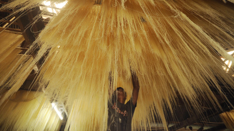 Un trabajador indio seca 'seviiyan', un alimento que se utiliza para la preparación del tradicional plato dulce sheerkhurma durante el mes del Ramadán, en una fábrica en Agartala, en India. Arindam DEY / AFP