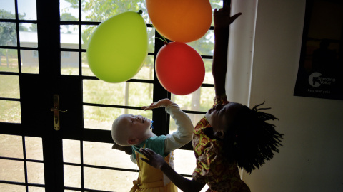 Una niña albina juega con globos en Ukerewe, en el Lago Victoria durante el Día Internacional de Sensibilización sobre el Albinismo. CARL DE SOUZA / AFP