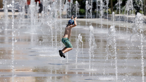 Un niño se refresca en las fuentes del Parque del Oeste de Valencia.