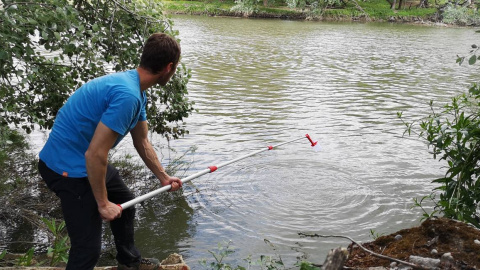 Un voluntario recoge muestras de agua del río Torío a su paso por León, cerca de un vertedero ilegal.