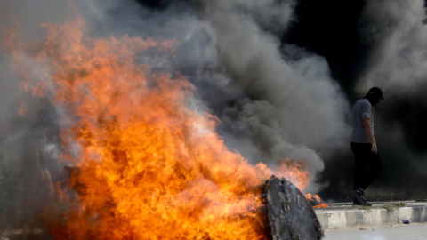 13/10/23 Un hombre, tras una barricada de fuego durante las protestas propalestinas en Nablús, en Cisjordania.