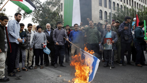 13/10/23 Varias personas queman una bandera israelí durante una manifestación propalestina en Teherán (Irán).