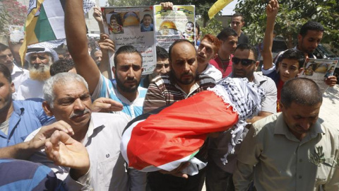 Un grupo de palestinos muestra el cuerpo sin vida de Ali Dawabsha, de 18 meses de vida, durante su funeral en Nablus (Cisjordania) hoy, 31 de julio de 2015. El secretario general de la Organización para la Liberación de Palestina (OLP) y je