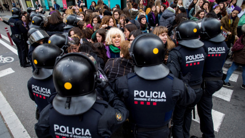 Efectivos de los Mossos d'Esquadra desalojan a un grupo de mujeres que cortaban la Gran Via de Barcelona.- EFE