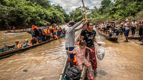 Una migrante venezolana baja junto a su hija de una canoa tras cruzar la selva del Darién, que separa Colombia de Panamá, en su ruta migratoria hacia EEUU.