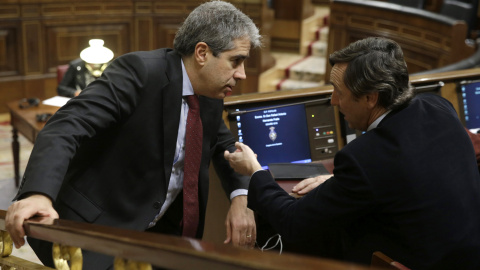 El portavoz de Democràcia i Llibertat (DiL), Francesc Homs (i), conversa con el portavoz del PP, Rafael Hernando (d), durante la sesión de la tarde de la segunda jornada del debate de investidura del secretario general del PSOE, Pedro Sánch