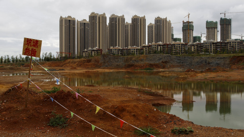 Un letrero que dice "Estanque, peligro", junto a las obras de unas edificaciones residenciales en Chenggong, en la provincia china de Yunnan. REUTERS / Wong Campion