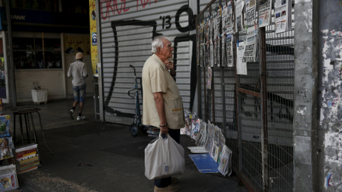 Un hombre lee los titulares de los periódicos expuestos en un quiosco en Atenas. REUTERS/Alkis Konstantinidis