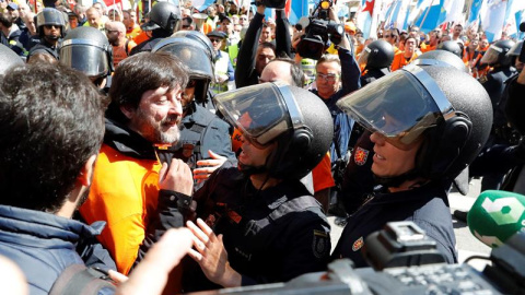 El diputado de Podemos, Rafa Mayoral (2i), conversa con agentes de Policía, durante la concentración de trabajadores de Alcoa. /EFE