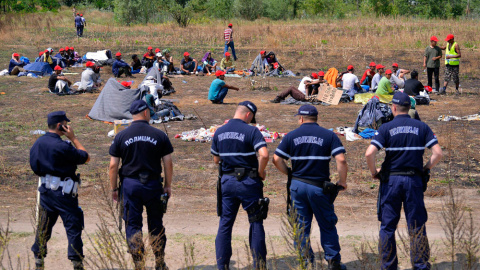 Policías serbios vigilan a un grupo de refugiados que permanecen en huelga de hambre en la frontera serbo-húngara cerca de Horgos. EFE