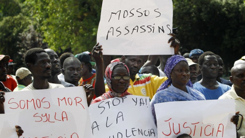 Inmigrantes senegaleses muestran pancartas contra la los Mossos D'esquadra en la manifestació en Salou para protestar por la muerte de un compatriota en una operación contra el 'top manta'. AFP PHOTO / QUIQUE GARCIA