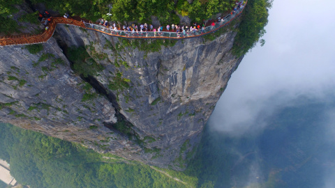 Un grupo de gente camina sobre la plataforma de un mirador en Zhangjiajie, en la provincia de Hunan, China. REUTERS/Stringer