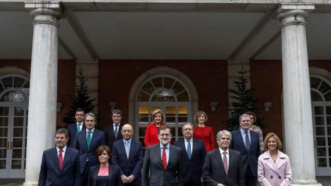 El jefe del ejecutivo, Mariano Rajoy, durante la foto oficial de su nuevo Ejecutivo tras la incorporación de Román Escolano, arriba a la izquierda. | EMILIO NARANJO (EFE)