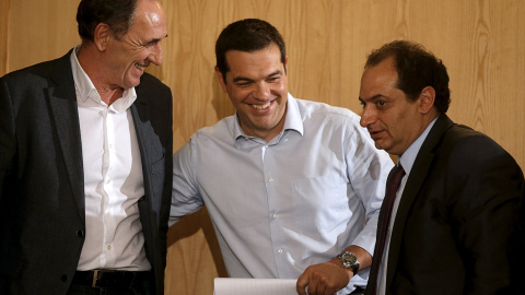 El primer ministro griego, Alexis Tsipras, con el ministro de Economía,  Giorgos Stathakis, y el de Infraestructuras, Christos Spirtzis, tras un acto  en Atenas, el primero tras el acuerdo entre el Ejecutivo heleno y la troika para el terce