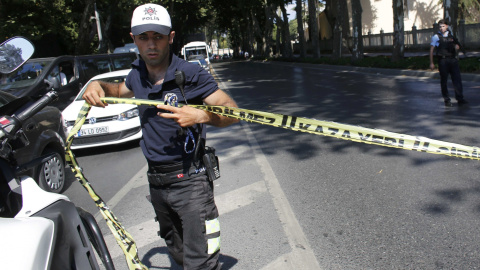 Un policía turco coloca una cinta para acotar la zona cercana al Palacio de Dolmabahçe, en Estambul, donde se ha producido un tiroteo. REUTERS/Murad Sezer