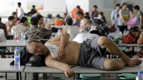 Un hombre descansa en el comedor de la escuela donde han sido realojados los afectados. REUTERS