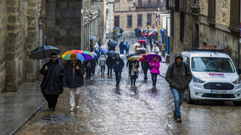 Varias personas caminan bajo la lluvia en Toledo, a 3 de enero de 2024.